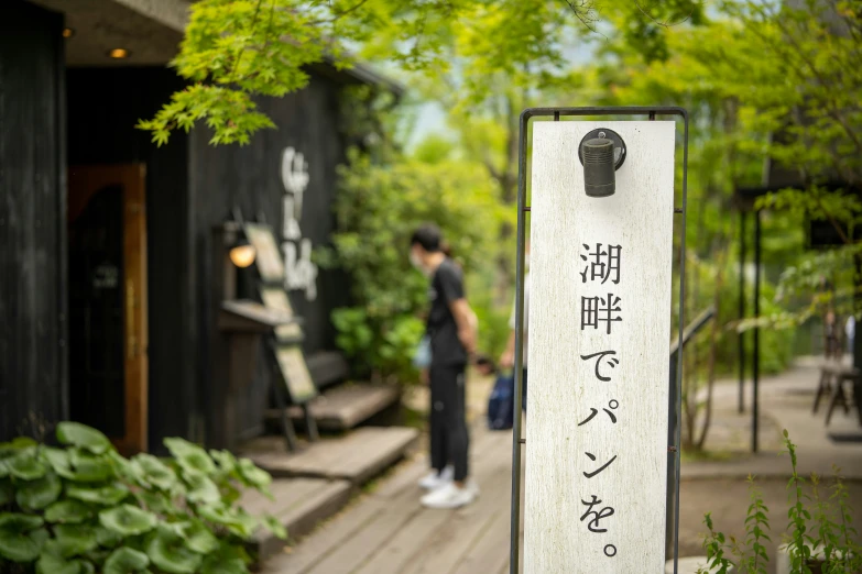 two persons standing on a wooden walkway near trees