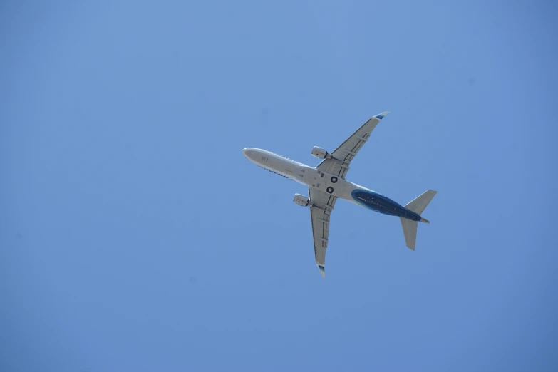 the bottom of an airplane flying through the blue sky