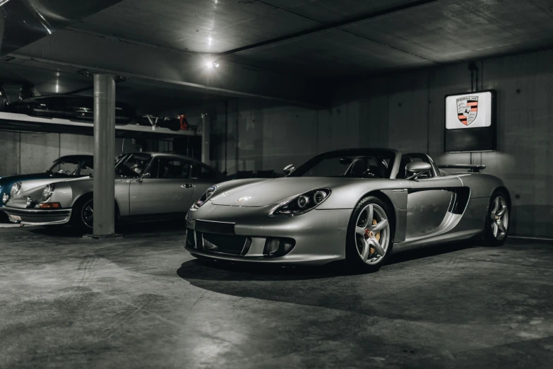 two silver sports cars in a parking garage