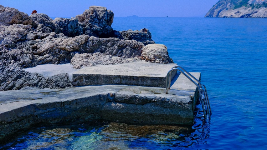 an ocean view of the rocks in the water and the lighthouse