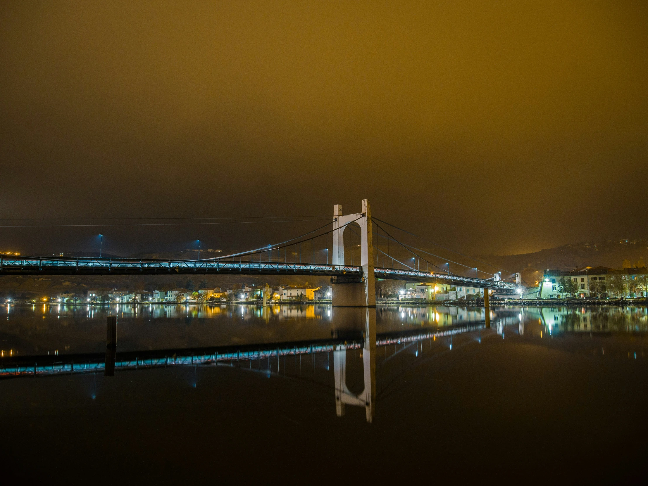 the view of the bay bridge at night from the shore