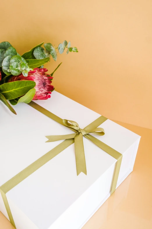 a bunch of flowers sitting in a large white gift