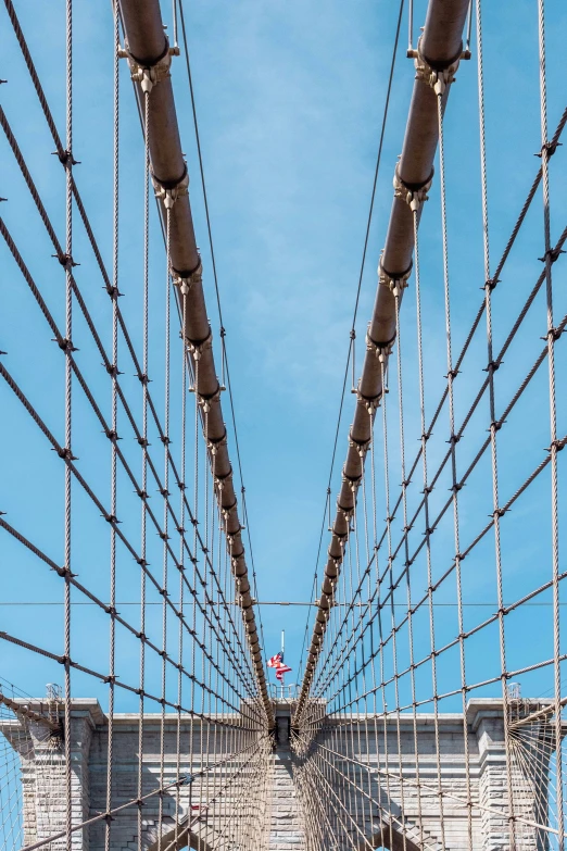 the high ropes that make up the suspension bridges are being adjusted by construction workers