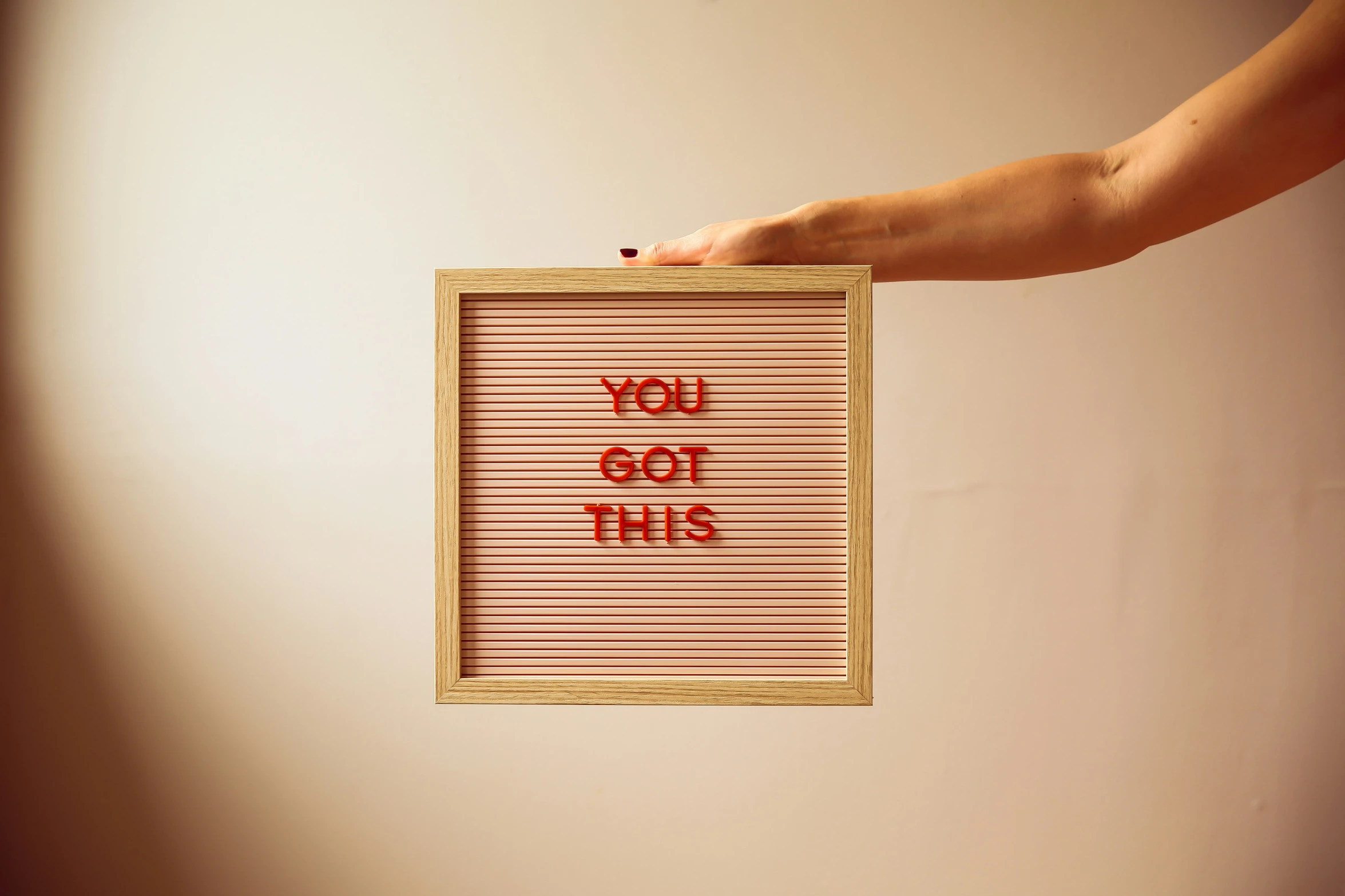 a person holds a sign with red writing on it