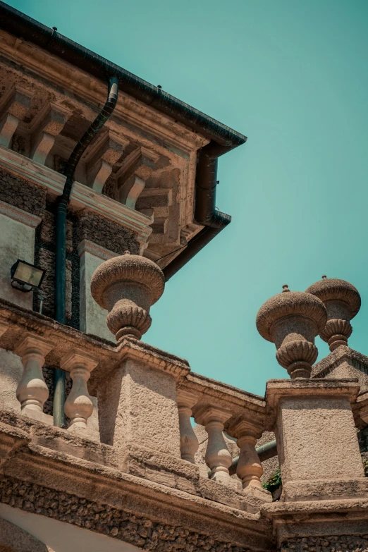 the top of two ornate buildings against a bright blue sky