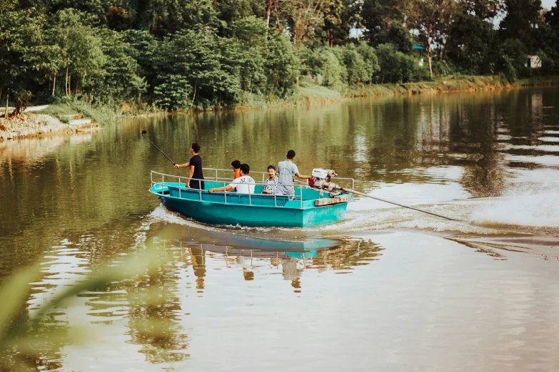 four people in blue boat on water near shore