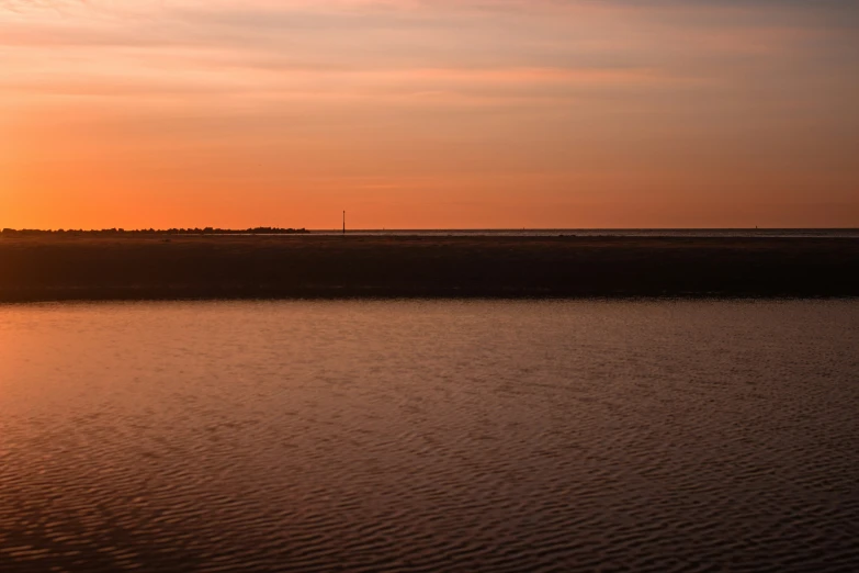 a sunset is seen from the shoreline with water