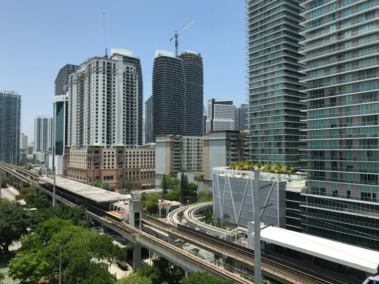 a view of a city from a bridge in the foreground, with train tracks on both sides and buildings in the back