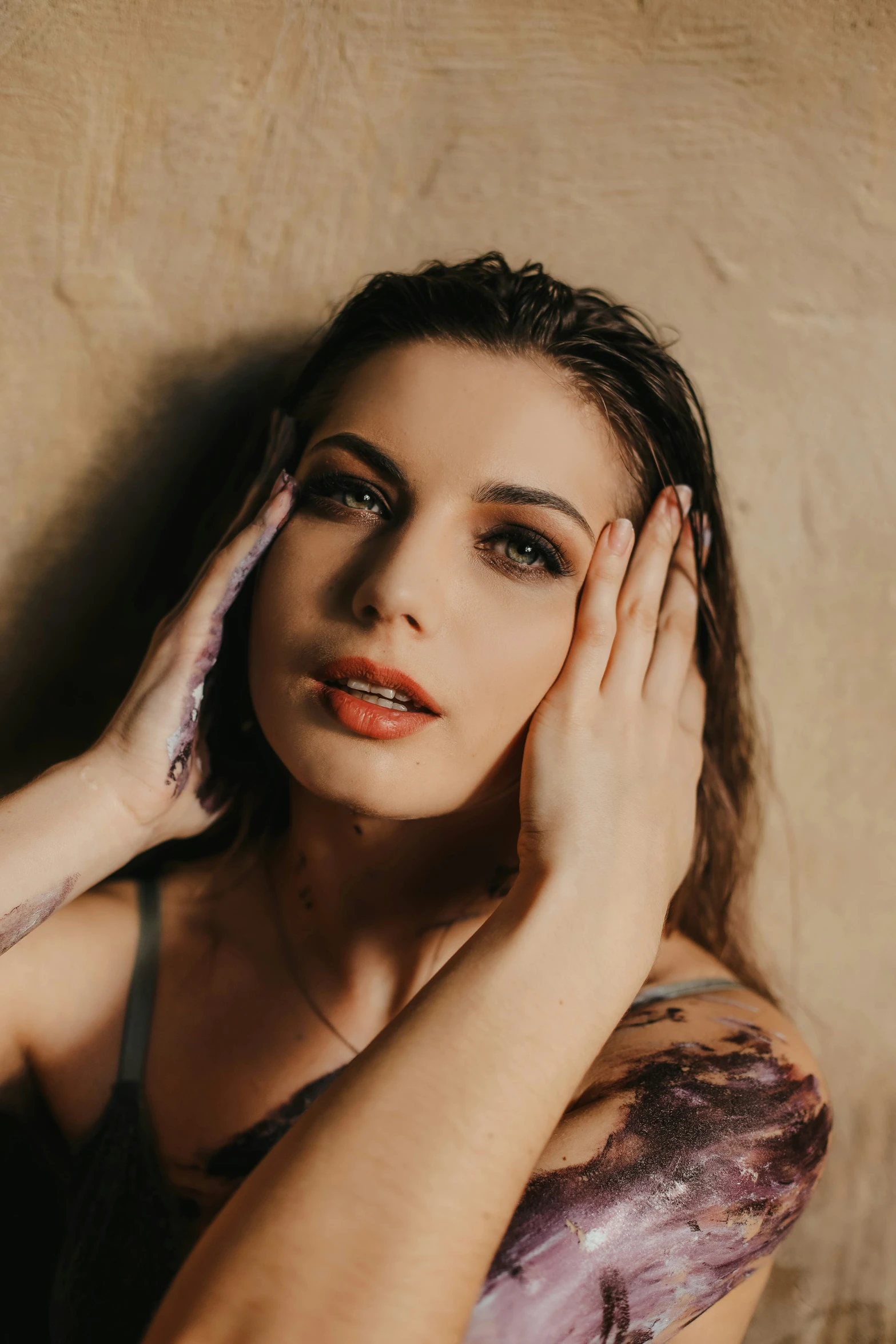 a woman with long hair holding her face and her hand to her face