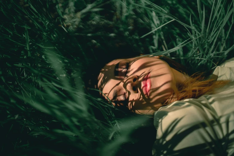 the lady is relaxing in the grass outside