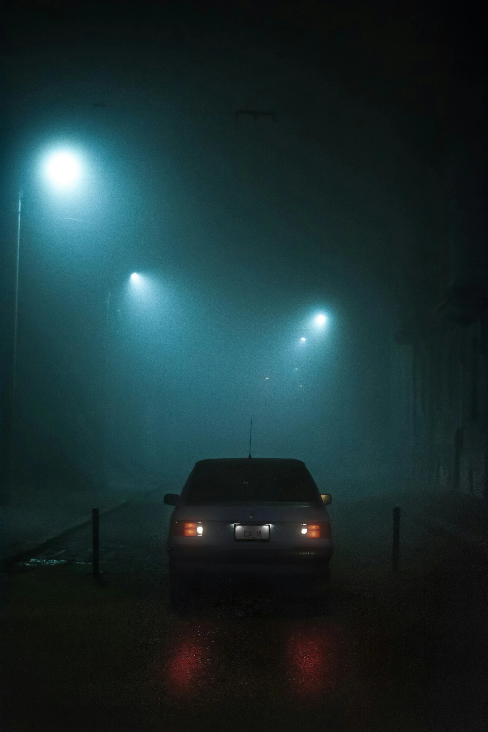 a car driving down a street in the dark