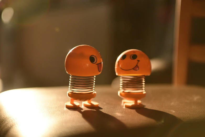 a couple of little plastic robot heads sit on a table