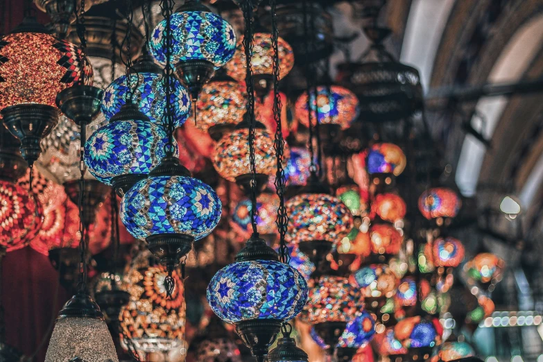 many colorful light bulbs hanging from a ceiling