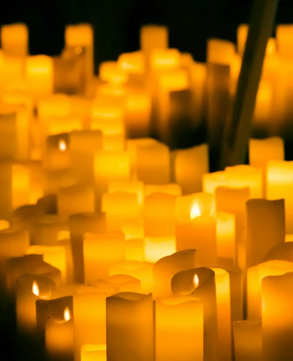 many white lit candles that have been placed together