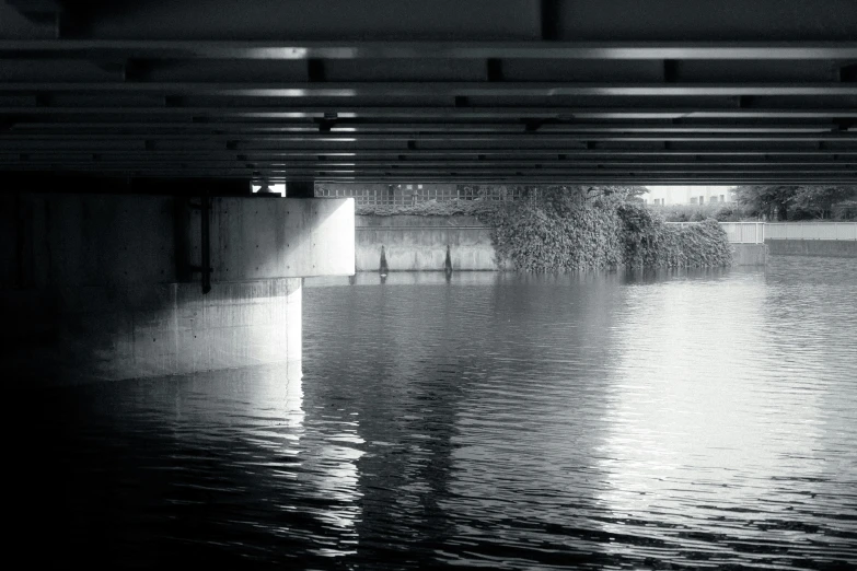 black and white po of water under a bridge