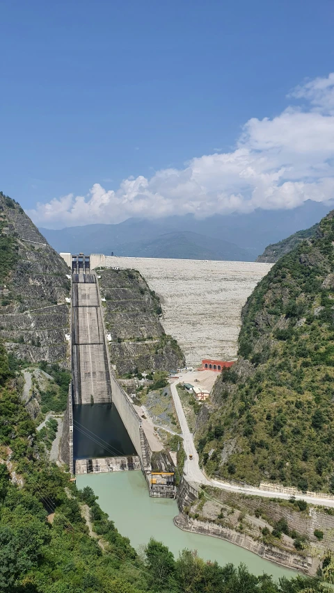 a bridge over a river next to lush green mountains