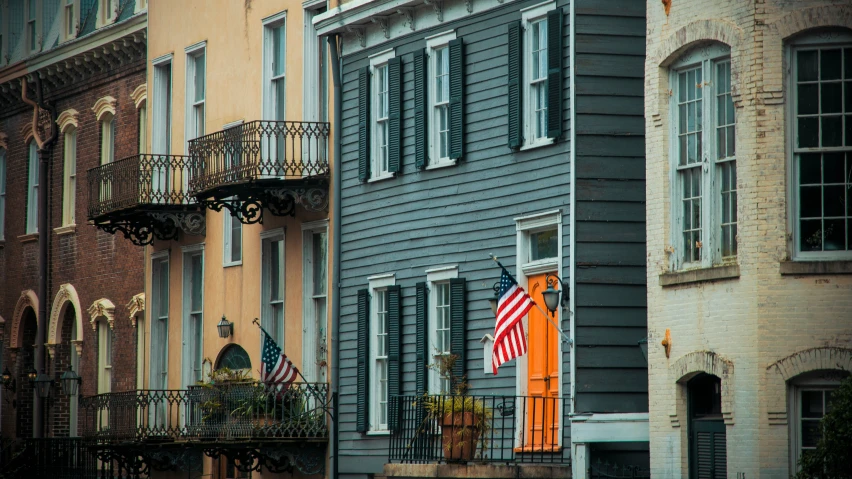 a red, white and blue flag is flying on top of a building in a city