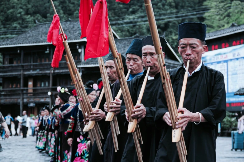 men in traditional dress carrying flags during a procession