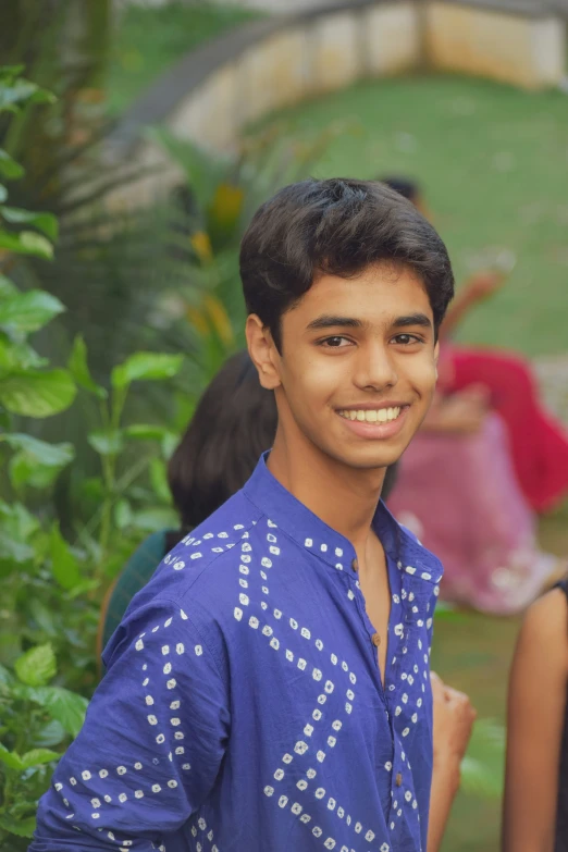 a smiling young man in blue standing on the ground