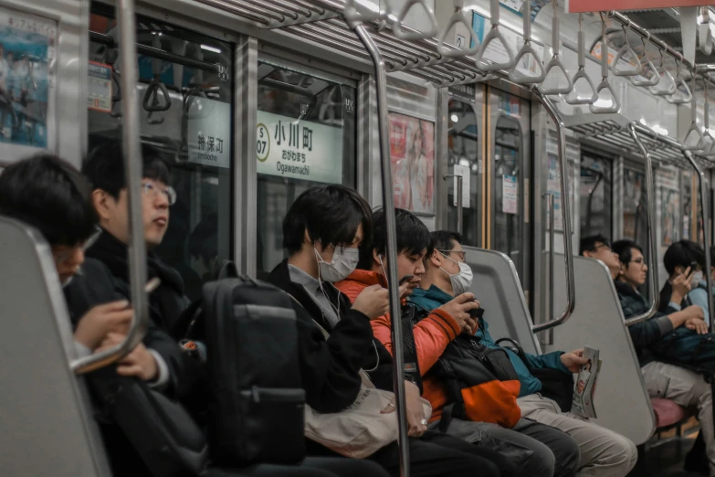 passengers sitting on a metro train in masks