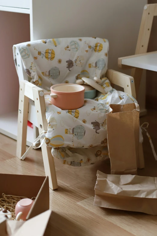 a baby chair sitting in front of a brown bag