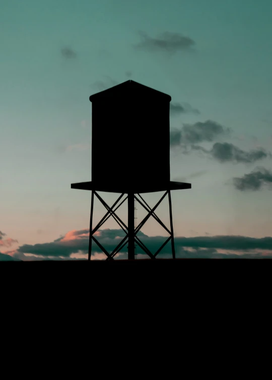 a silhouette of a tower with a sunset in the background