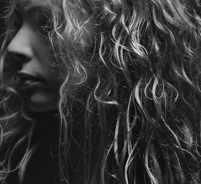 a black and white po of a woman's curly hair