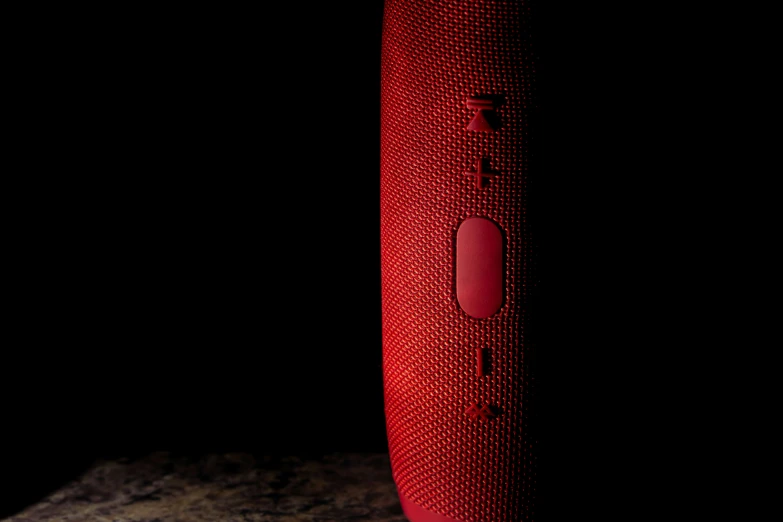 a speaker made of red material on a rock