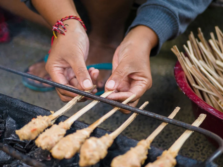 two people standing over a food platter that they are cooking