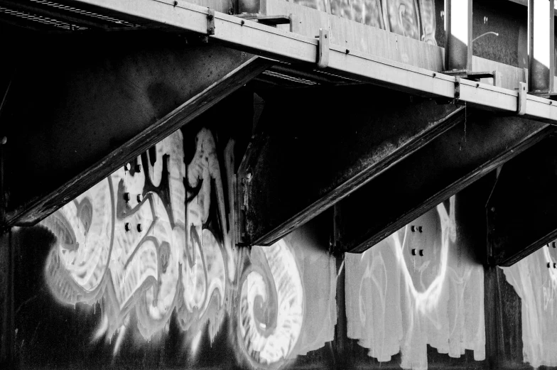 graffiti on the side of a bridge on a sunny day