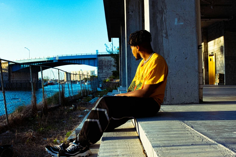 a man sitting on steps looking down at the water