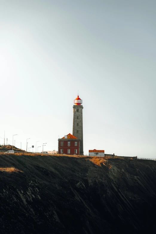 a light house on top of a hill next to a lighthouse