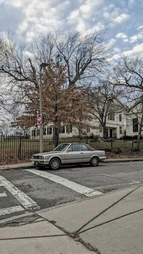 the silver car is driving around a corner at the stop light