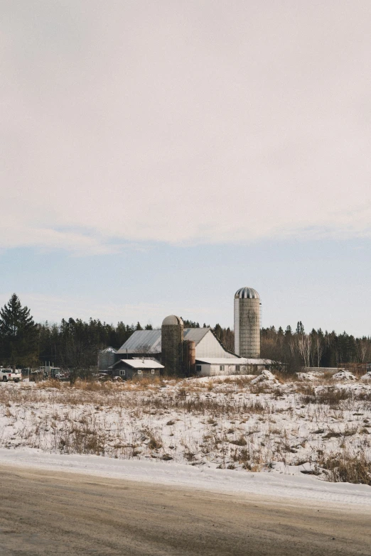 a big field with some barn in the background