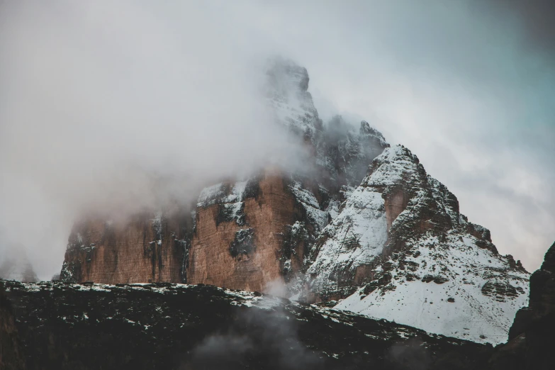 snow covered mountain peaks with a low cloud moving in