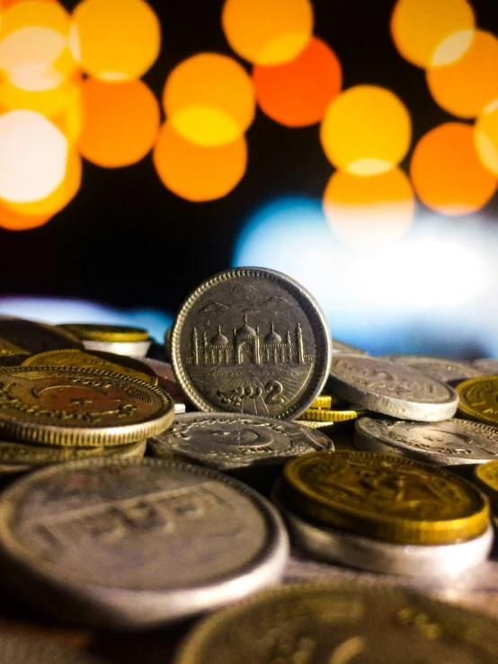 several different indian coins lying on a table