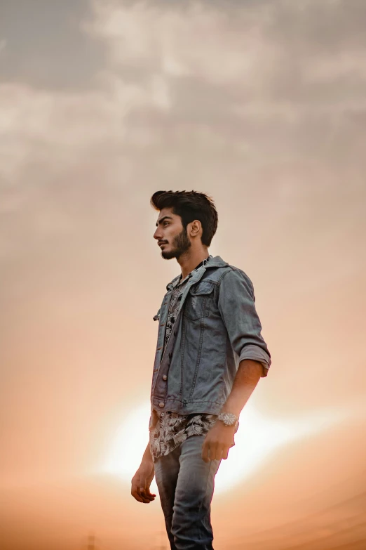 a young man standing on top of a dirt hill