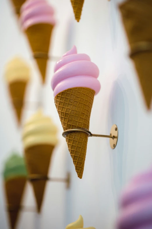 several ice cream cones are being hung from the ceiling