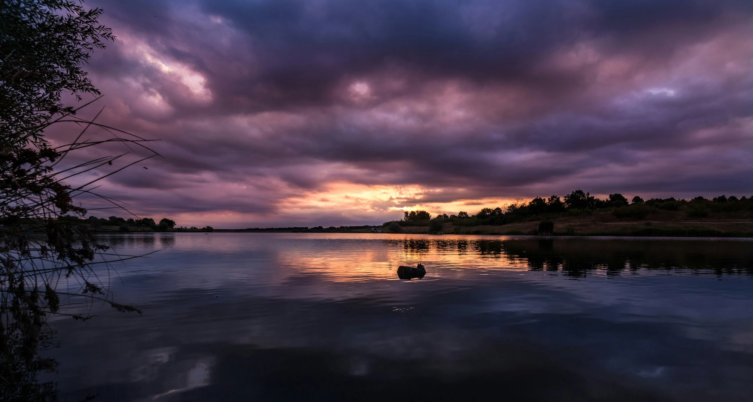 an overcast, drab sky sits over a lake in this image