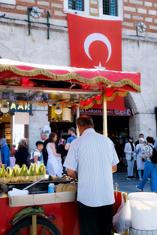 a person is selling food at a stand