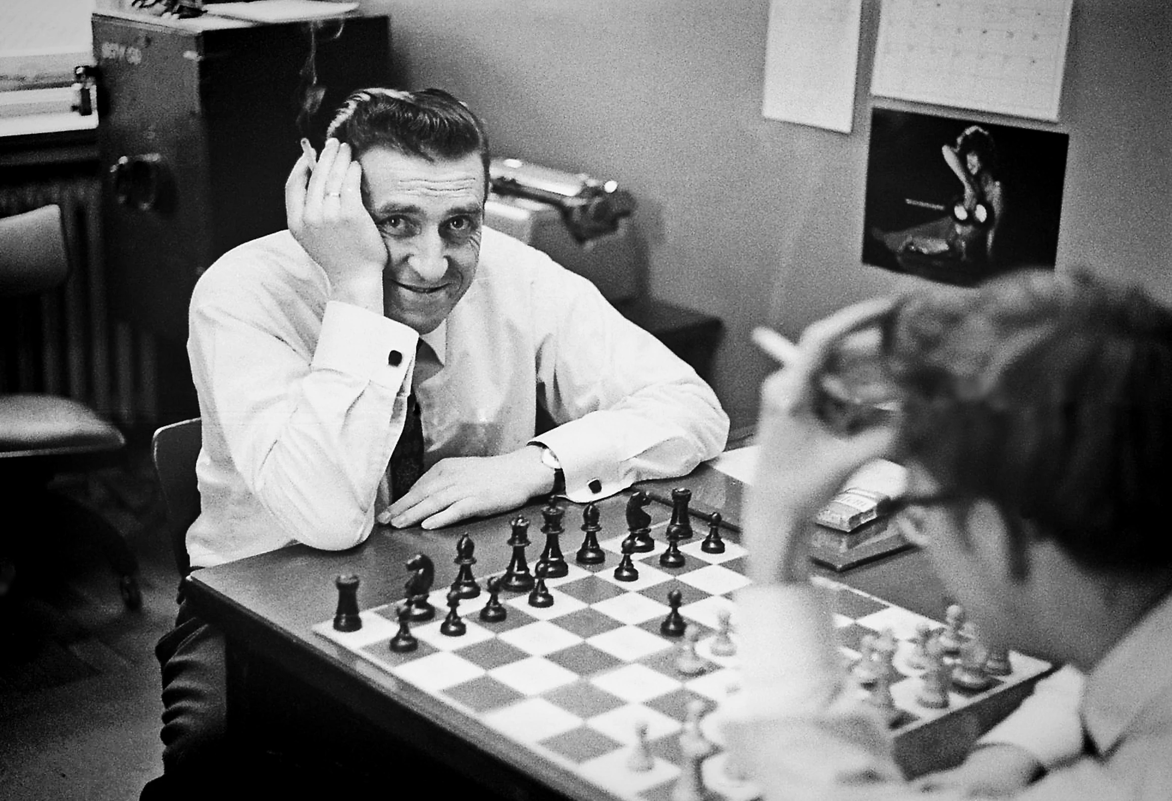 a man is playing chess with two little girls