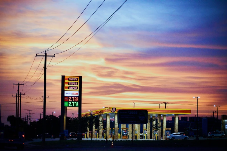 an empty gas station with cars at night