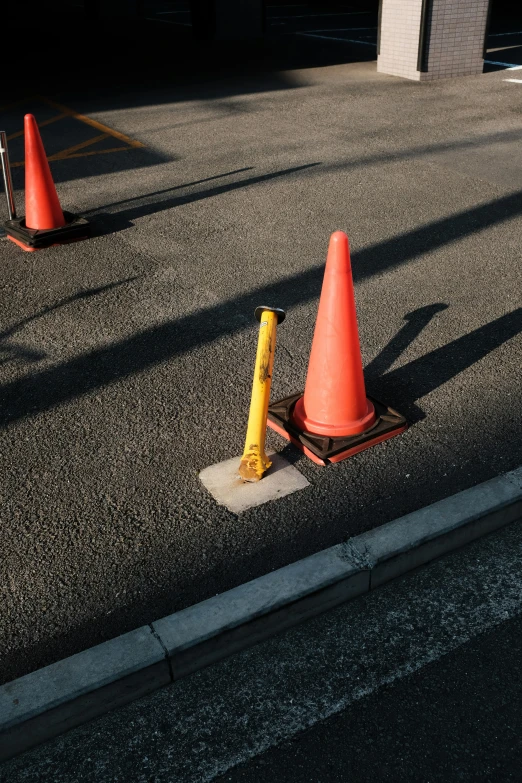 three cones sitting on the side of a road