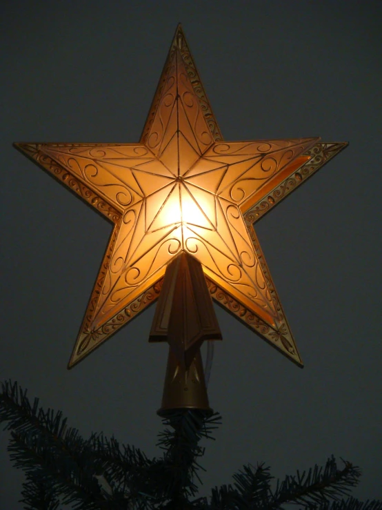 an illuminated light - up star mounted in the shape of a bell