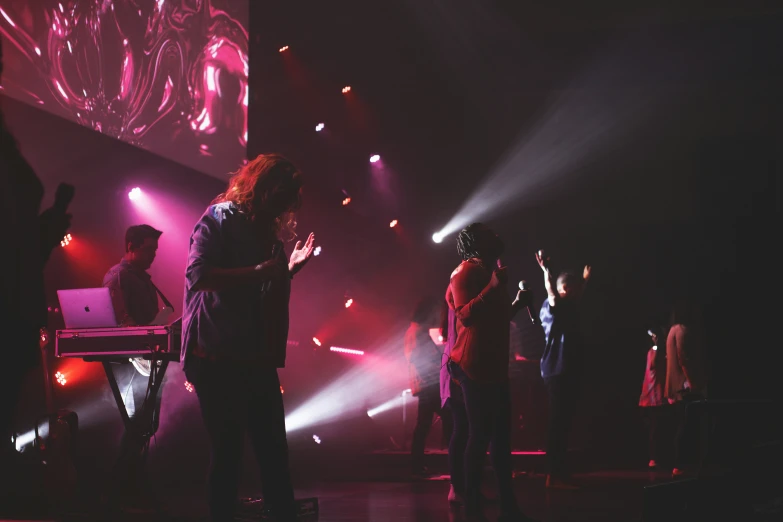 people are standing and singing on stage