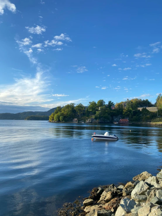 the sun is low on a clear, blue sky over a quiet body of water