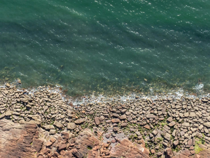 a rocky shore line with some rocks and water