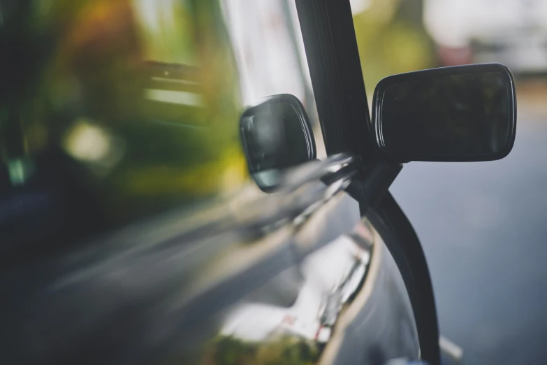 side view mirror of a car parked on a street