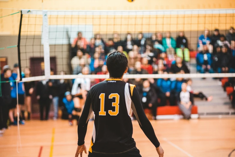 the young man in black jersey is playing volleyball