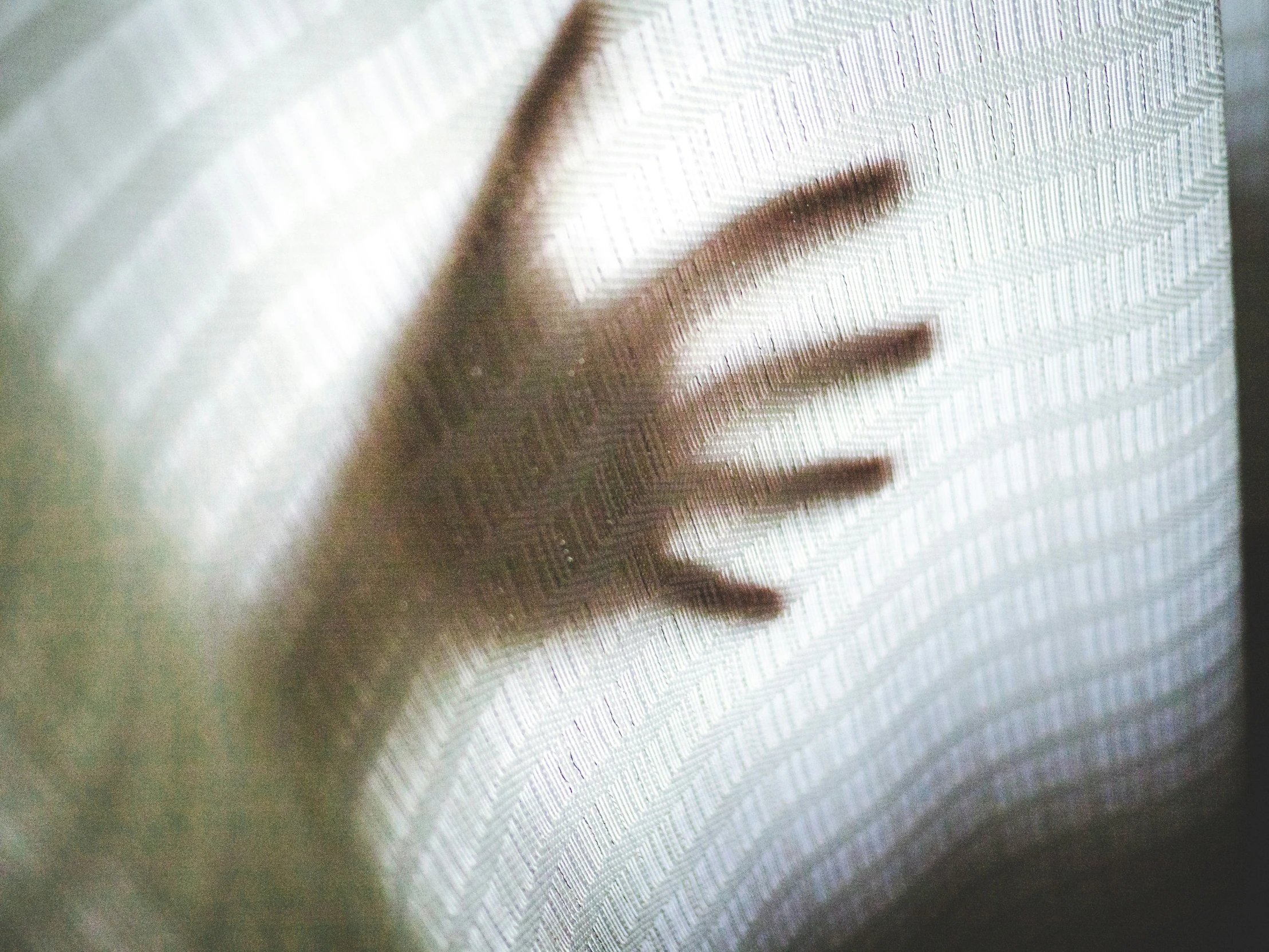 a shadow picture with someone's hand reaching out from the screen